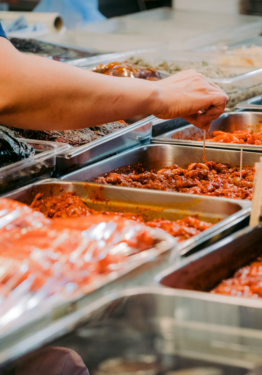Hands reaching for food at a buffet
